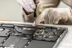 Mitarbeiter repariert das Logicboard an einem MacBook Pro - professionelle Logicboard-Reparatur