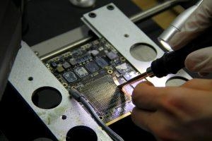 Nahaufnahme einer iMac-Grafikkarte, die für eine Reparatur vorbereitet wird.