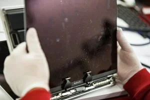 Staubeinschlüsse unter dem Display eines MacBook – typischer Dustgate-Fehler